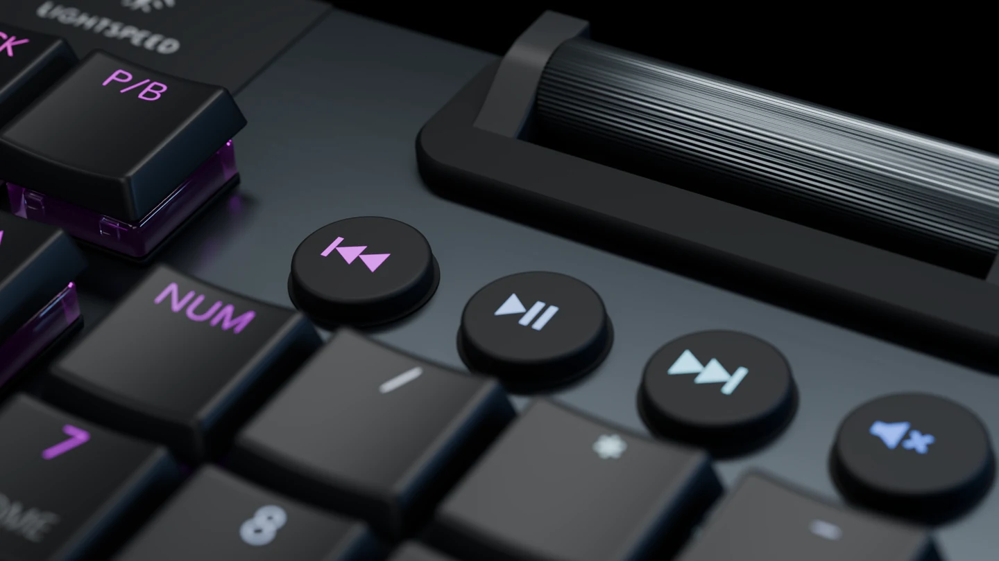 Detalhe do controle de volume em metal e dos quatro botões de mídia do teclado.